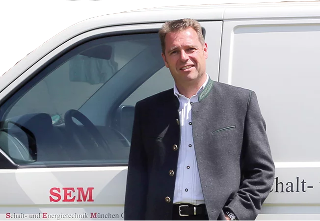 Bild von Herr Kerschl vor einem Fahrzeug.